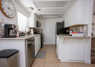 a kitchen with white cabinets and a clock on the wall at Comfort meets Tranquility by the Sequoia Entrance in Three Rivers