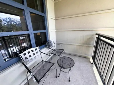 two chairs and a table on a balcony at Luxury 2 Bedroom Penthouse with Stunning Views! in Mammoth Lakes