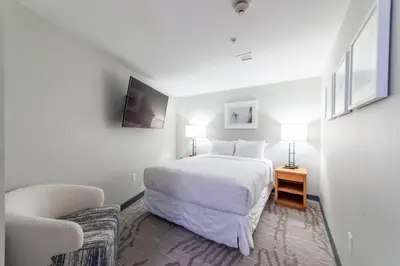 a white bedroom with a bed and a chair at Luxury 2 Bedroom Penthouse with Stunning Views! in Mammoth Lakes