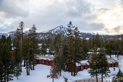 a lodge in the snow with trees and mountains at Luxury 2 Bedroom Penthouse with Stunning Views! in Mammoth Lakes
