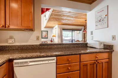 a kitchen with wooden cabinets and a counter top at Courchevel #15 - 2 Bedroom, 2 Bathroom, Sleeps 6! Just steps to Canyon Lodge! in Mammoth Lakes
