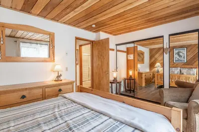 a bedroom with a bed and a living room at Courchevel #15 - 2 Bedroom, 2 Bathroom, Sleeps 6! Just steps to Canyon Lodge! in Mammoth Lakes