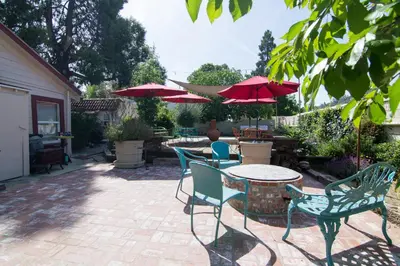 a patio with tables and chairs and red umbrellas at River Rock Inn in Mariposa