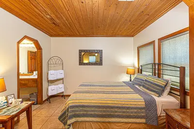 a bedroom with a bed with a wooden ceiling at River Rock Inn in Mariposa