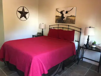 a bedroom with a bed with a red bedspread at River Rock Inn in Mariposa