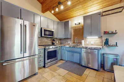 a kitchen with stainless steel appliances and blue cabinets at Wild Horse Hideaway in Incline Village