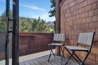 two chairs and a table on a deck at Palisades Condo - Walk to Ski Lift! in Olympic Valley