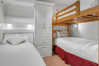 a bedroom with two beds and a bunk bed at Palisades Condo - Walk to Ski Lift! in Olympic Valley