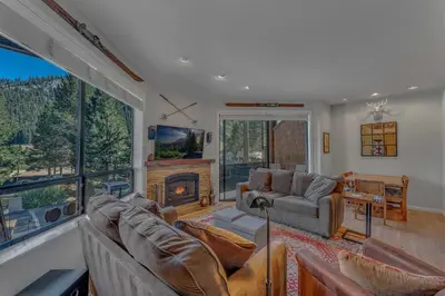 a living room with couches and a fireplace at Palisades Condo - Walk to Ski Lift! in Olympic Valley
