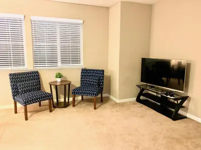 a living room with two chairs and a flat screen tv at Cheerful & Spacious house to relax and unwind in Tracy