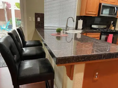 a kitchen with a counter with two bar stools at Cheerful & Spacious house to relax and unwind in Tracy