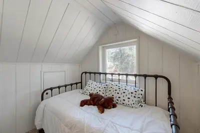 a teddy bear laying on a bed in a room at 10 Mi to Bear Valley Resort Serene Mtn Retreat in Tamarack