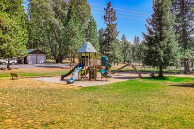 a playground with a slide in a park at California Mountain Cabin with Lake Access and Deck! in Long Barn