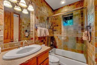 a bathroom with a sink and a tub and a toilet at Lakefront Retreat Across from Homewood Resort in Homewood