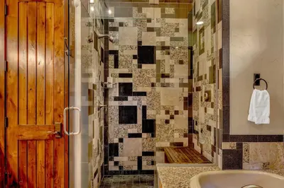 a bathroom with a shower with a sink and a tub at Lakefront Retreat Across from Homewood Resort in Homewood