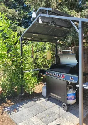 a barbecue grill under a pergola in a backyard at 3 Bedrooms,Beautiful House with Hot Tub, Pool Oasis and Fire Pit in Clovis