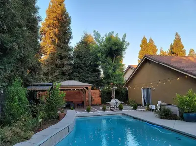 a swimming pool in the backyard of a house at 3 Bedrooms,Beautiful House with Hot Tub, Pool Oasis and Fire Pit in Clovis