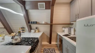 a kitchen with a stove top oven next to a counter at Speckled by AvantStay Modern Interior 0.5mi to Lake in Kings Beach