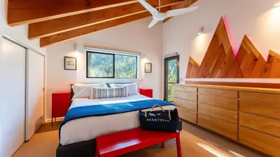 a bedroom with a large bed and a red bench at Trapper by AvantStay A Interior Design w Sauna in Alpine Meadows