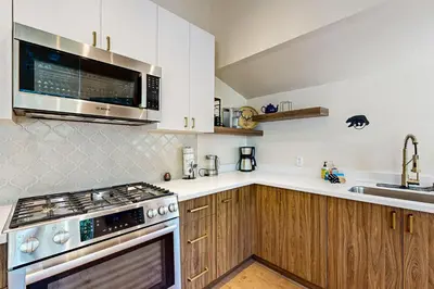 a kitchen with wooden cabinets and a stove top oven at Modern Mountain Getaway in Olympic Valley