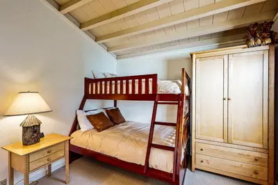 a bedroom with a bunk bed and a desk with a lamp at Modern Mountain Getaway in Olympic Valley