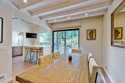 a dining room and kitchen with a wooden table and chairs at Modern Mountain Getaway in Olympic Valley