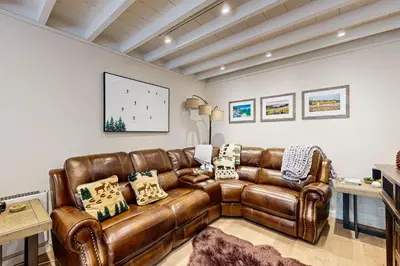 a living room with a brown leather couch at Modern Mountain Getaway in Olympic Valley