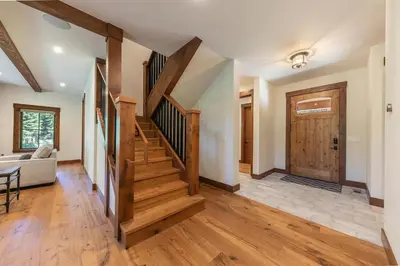 a living room with wooden stairs and a door at Arcadia Manor on the West Shore - Newly Built - 5 BR w Wet Bar EV Charger and Air Conditioning in Tahoe City