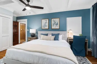 a bedroom with a large bed and a blue wall at Luxe Retreat Designed For Group Getaways in Lodi