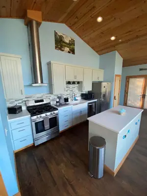 a kitchen with white cabinets and a stove top oven at The Hilltop Cabin Retreat in Bass Lake Heights in Oakhurst
