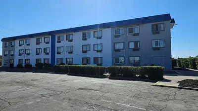 a large white building with bushes in front of it at MetroParc 'nSuites in Stockton