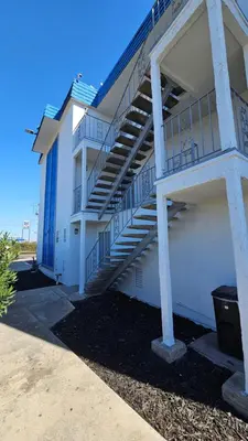 a white building with stairs on the side of it at MetroParc 'nSuites in Stockton