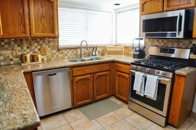 a kitchen with wooden cabinets and a stove top oven at Fernwood Retreat at Madera Ranchos in Madera