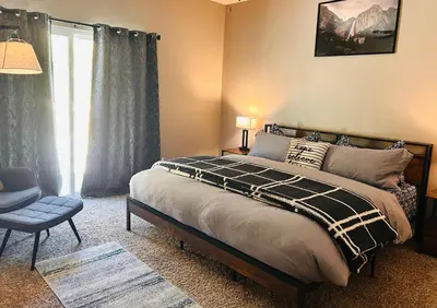 a bedroom with a bed and a chair and a window at Yosemite Hilltop Gated Villa near Oakhurst, Bass Lake and Mariposa w EVCharger Hottub Grill and Awesome Views! in Ahwahnee
