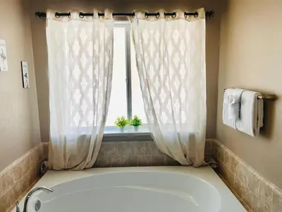 a bath tub in a bathroom with a window at Yosemite Hilltop Gated Villa near Oakhurst, Bass Lake and Mariposa w EVCharger Hottub Grill and Awesome Views! in Ahwahnee
