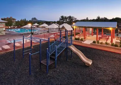 a playground with a slide in front of a pool at WorldMark Angels Camp - 1BD in Angels Camp