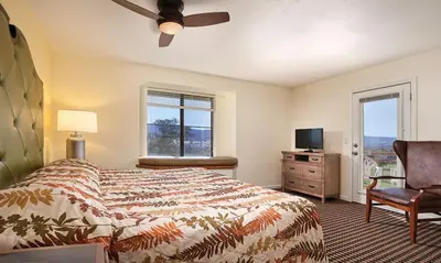 a bedroom with a bed and a chair and a television at WorldMark Angels Camp - 2BD in Angels Camp