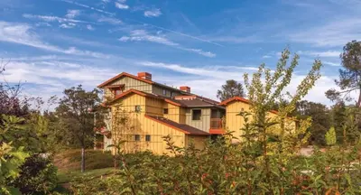 a large yellow house in the middle of a field at WorldMark Angels Camp - 2BD in Angels Camp