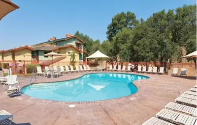 a large swimming pool with chairs and a house at WorldMark Angels Camp - 2BD in Angels Camp
