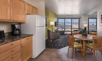 a kitchen with a refrigerator and a table with chairs at Great 1BD condo with resort amenities take in all Reno has to offer in Reno