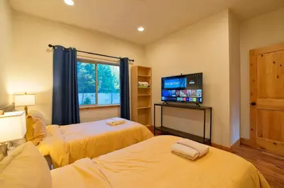 a room with two beds and a flat screen tv at CHALET LU - Modern Luxury 4 bed 2.5 bath Chalet by Lake Baron in South Lake Tahoe in South Lake Tahoe