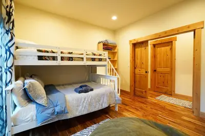 a bedroom with two bunk beds and a staircase at CHALET LU - Modern Luxury 4 bed 2.5 bath Chalet by Lake Baron in South Lake Tahoe in South Lake Tahoe