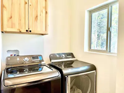 a washer and dryer in a kitchen with a window at CHALET LU - Modern Luxury 4 bed 2.5 bath Chalet by Lake Baron in South Lake Tahoe in South Lake Tahoe