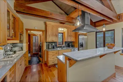 a large kitchen with wooden cabinets and a counter top at Alpine Meadows Retreat 3 Min to Base with Hot Tub in Alpine Meadows