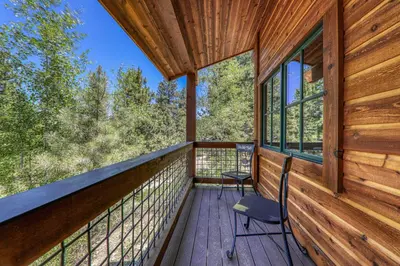 a deck with two chairs and windows on a cabin at Compass Luxury Lodge - Access to HOA and Free Shuttle! in Truckee