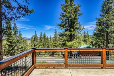 a deck with a view of the woods at Compass Luxury Lodge - Access to HOA and Free Shuttle! in Truckee