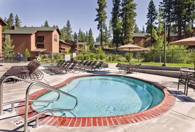 a swimming pool with chairs and tables and a building at Wyndham South Shore 2bd sleeps 6 in Zephyr Cove