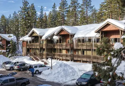 a lodge in the snow with cars parked in a parking lot at Worldmark South Shore 2bd- sleeps 6 in Zephyr Cove