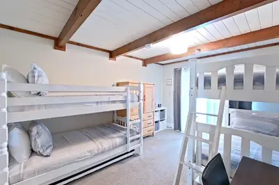a room with two bunk beds and a table at The Valley View- Pine Mountain Lake Cabin home in Groveland