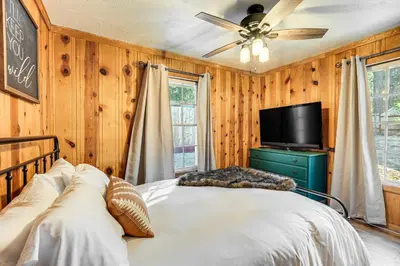 a bedroom with a bed and a flat screen tv at Hike, Ski and Fish Charming Cabin in Twain Harte! in Twain Harte